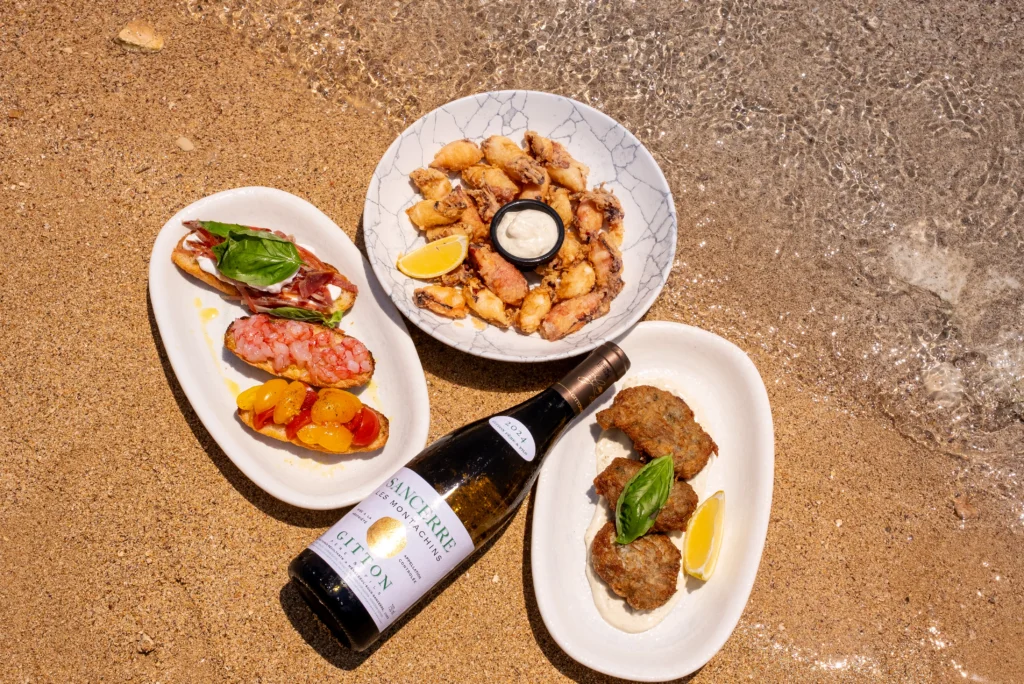 Mediterranean sharing plates on the sand beside the water